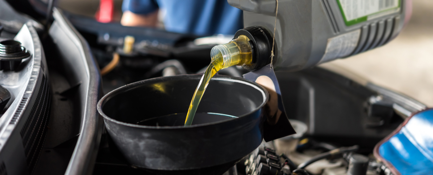 Mechanic pouring engine oil into a vehicle - Car Servicing Dudley